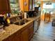 Functional kitchen featuring wood cabinets, granite countertops, and stainless steel appliances at 1354 Linstock Dr, Holiday, FL 34690