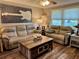 Cozy living room with comfortable seating, wood flooring, and a rustic coffee table centerpiece at 1354 Linstock Dr, Holiday, FL 34690