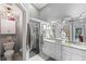 Modern bathroom featuring double sinks, granite countertops and a large walk-in shower at 1400 Summerwood Ct, Spring Hill, FL 34606