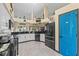 Modern kitchen featuring white cabinets, black appliances, and a blue accent wall at 1400 Summerwood Ct, Spring Hill, FL 34606