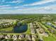 Aerial view of houses and a lake in a residential community at 19907 Tattnall Way, Brooksville, FL 34601