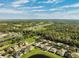 Aerial view of houses and green spaces near a lake at 19907 Tattnall Way, Brooksville, FL 34601