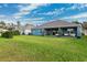 Home with covered patio, lush lawn, and mature trees at 19907 Tattnall Way, Brooksville, FL 34601
