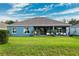 House with a large backyard, covered patio, and seating area at 19907 Tattnall Way, Brooksville, FL 34601