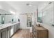 Elegant bathroom with double vanity, walk-in shower, and a modern barn door at 19907 Tattnall Way, Brooksville, FL 34601