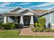 Front entrance of a two story home with gray exterior and brick walkway at 19907 Tattnall Way, Brooksville, FL 34601