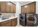 Bright laundry room with wooden cabinets and a sink at 19907 Tattnall Way, Brooksville, FL 34601