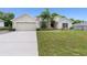 Front exterior of a single-Gathering home with a two-car garage, driveway, and lawn at 2468 Magellan Ave, Spring Hill, FL 34608