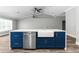 Kitchen island with a farmhouse sink, dishwasher, and blue shaker cabinets at 2468 Magellan Ave, Spring Hill, FL 34608