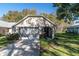 Tan house with garage and screened porch, green lawn at 4902 Leyte Ct, New Port Richey, FL 34655