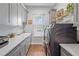 Laundry room with gray cabinets, quartz countertops, and a window offering natural light at 5618 Summit View Dr, Brooksville, FL 34601