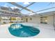 Inviting kidney-shaped pool with a screened enclosure and patio area at 6280 Hancock Ave, Spring Hill, FL 34608