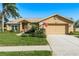 Tan one-story house with a two-car garage and American flag at 6604 Rosemont Ct, New Port Richey, FL 34655
