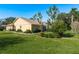 Tan house with landscaping and a screened patio at 6604 Rosemont Ct, New Port Richey, FL 34655