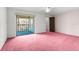 Main bedroom with pink carpet, a ceiling fan, and balcony access at 7721 Cosme Dr # B, Hudson, FL 34667