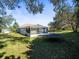 Grass backyard with trampoline and screened enclosure at 10307 Ridge Top Loop, Weeki Wachee, FL 34613