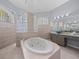 Bathroom with soaking tub, glass block window, and granite vanity at 10307 Ridge Top Loop, Weeki Wachee, FL 34613