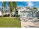 Light green house with a two-car garage and well-manicured lawn at 10514 Salisbury St, Riverview, FL 33569