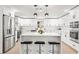 Modern white kitchen with stainless steel appliances and an island with seating at 10744 Drummond Rd, Tampa, FL 33615