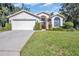 Single-story home with a two-car garage and well-manicured lawn at 11445 Deercroft Ct, Spring Hill, FL 34609