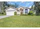 Single-story home with a two-car garage and well-manicured lawn at 11445 Deercroft Ct, Spring Hill, FL 34609