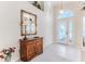 Bright entryway with tiled floors, a wooden console table, and a mirror at 11544 Mcleod St, Spring Hill, FL 34609