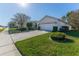 House exterior featuring a two-car garage and well-manicured lawn at 11544 Mcleod St, Spring Hill, FL 34609