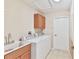 Bright laundry room, washer, dryer, cabinets and sink at 11544 Mcleod St, Spring Hill, FL 34609