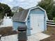 Detached storage shed with white doors and gray roof at 1418 Escobar Ave, Spring Hill, FL 34608