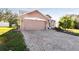 Two-story house with a brown facade, brick driveway, and palm tree at 1427 Loretto Cir, Odessa, FL 33556