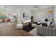 Bright living room featuring hardwood floors, modern furniture, and open layout to dining area at 2210 Utopian E Dr # 212, Clearwater, FL 33763