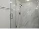 Walk-in shower with marble tile and glass enclosure at 2210 Utopian E Dr # 212, Clearwater, FL 33763