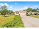 Single-Gathering home with tan exterior, attractive landscaping, and a two-car garage at 4201 Silver Berry Ct, Spring Hill, FL 34609