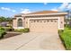 Tan house with a two-car garage and well-maintained landscaping at 4201 Silver Berry Ct, Spring Hill, FL 34609