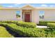 Front view of house with red door and manicured hedges at 4201 Silver Berry Ct, Spring Hill, FL 34609