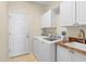 Laundry room with washer, dryer, cabinets, and a utility sink at 4201 Silver Berry Ct, Spring Hill, FL 34609