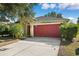 House exterior showcasing a red garage door and driveway at 714 Sea Holly Dr, Brooksville, FL 34604