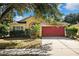 One-story house with red garage door and mature landscaping at 714 Sea Holly Dr, Brooksville, FL 34604