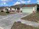 Front view of a ranch style home with a driveway and landscaping at 8525 Gandy Ln, Port Richey, FL 34668