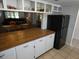 Kitchen with wood countertop, white cabinets, and black refrigerator at 9980 Eagles Point Cir # 3, Port Richey, FL 34668
