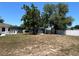 A spacious backyard with mature trees and a partial view of a screened in porch at 1000 Godfrey Ave, Spring Hill, FL 34609