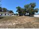 A large backyard featuring mature trees and a partial view of the home and screened porch at 1000 Godfrey Ave, Spring Hill, FL 34609