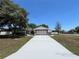 Charming single-story home featuring a white exterior, stone accents and a wide driveway at 1000 Godfrey Ave, Spring Hill, FL 34609
