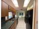 Galley kitchen features skylights, tiled floors, green countertops and black appliances at 1000 Godfrey Ave, Spring Hill, FL 34609