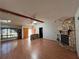 Spacious living room with stone fireplace, wood floors, wood beam and ample natural light at 1000 Godfrey Ave, Spring Hill, FL 34609