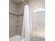 Clean bathroom with a shower/tub combo and arched window at 10464 Henderson St, Spring Hill, FL 34608