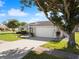 House with a two-car garage and a tree with a swing at 10464 Henderson St, Spring Hill, FL 34608