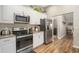 Modern kitchen with white cabinets, granite counters, and stainless steel appliances at 10464 Henderson St, Spring Hill, FL 34608