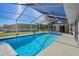 Enclosed rectangular pool with a concrete deck at 10464 Henderson St, Spring Hill, FL 34608