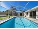Enclosed rectangular pool with a concrete deck at 10464 Henderson St, Spring Hill, FL 34608